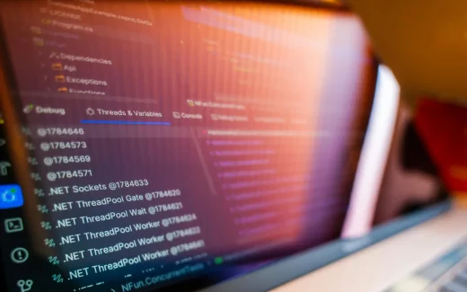 Kod och systemloggar på datorskärm i utvecklingsmiljö, symbol för molnbaserad kommunikation och API-tjänster kopplade till sinch aktie.
