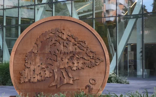 Swedbanks ek-symbol i metall placerad utanför modern bankbyggnad, som representerar stabilitet och långsiktig verksamhet kopplad till swedbank aktie.