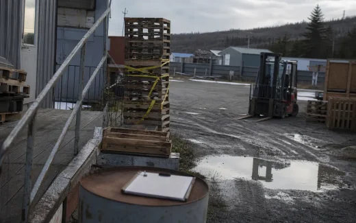 Lastbrygga med lastpallar och truck i overkast dagsljus